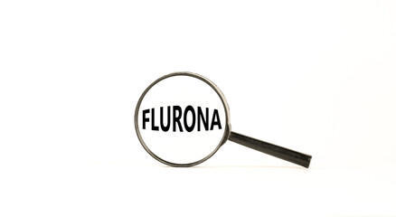 Covid-19 corona and flu flurona symbol. The concept word flurona. Magnifying glass. Beautiful white table, white background. Medical covid-19 corona and flu flurona concept. Copy space.