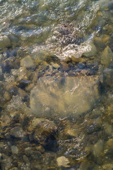 water flowing over rocks and ice in mountain river