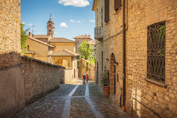 Couple walking a small alley in Castell'Arquato, Piacenza, Italy