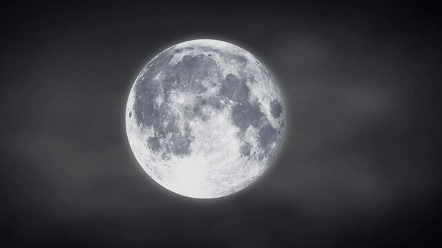 A full luminous moon with fog is slowly approaching in the frame, blowing winds during a night storm
