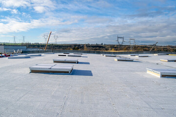 Construction of a flat roof with EPDM (ethylene propylene diene monomer) membrane on a large warehouse - obrazy, fototapety, plakaty