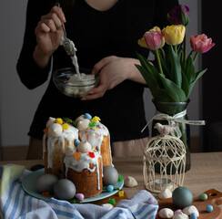 Girl decorating easter cake. Easter eggs and tulips. flowers