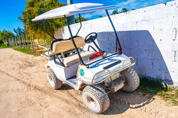 Fototapeta na wymiar Golf cart buggy cars carts muddy street village Holbox Mexico.
