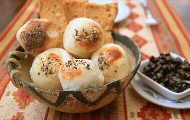 Homemade Argentinian Sesame Table Rolls in a Wooden Basket with Black Beans Dip