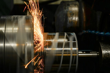 Roughing with a grinding abrasive wheel on a cylindrical grinder with sparks.