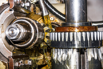 Making gears on a gear cutting machine. Machine oil cools the cutting process of the gear wheel...
