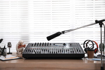Microphone near professional mixing console in radio studio