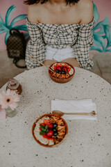 A young female blogger and influencer having an açai bowl in a trendy vegan cafe in Bali