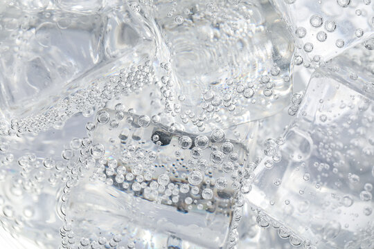Soda water with ice as background, closeup