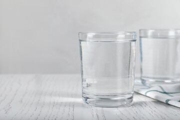 Glasses of soda water on white wooden table. Space for text