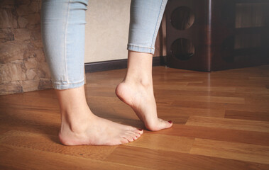 Female feet walking on floor at home.