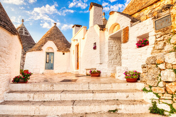 Fototapeta na wymiar Famous Trulli Houses during a Sunny Day with Bright Blue Sky in Alberobello, Puglia