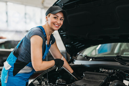 A professional female mechanic working in a car service.