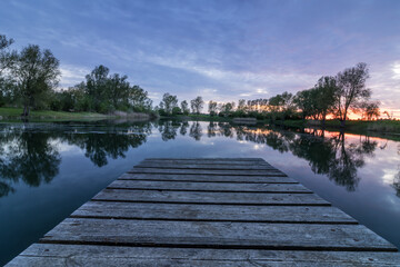 Jetty runs straight into the water after sunset at the lake