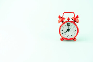 red alarm clock on a turquoise background in