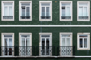 Close-up of traditional apartment building with green tiles facade