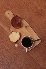 Muffin and white cup with coffee on the table. Cup of coffee and muffins for breakfast.