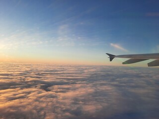 Blick aus dem Flugzeugfenster über den Wolken