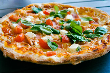 Close-up of fresh pizza with cherry tomatoes, feta and basil leaves