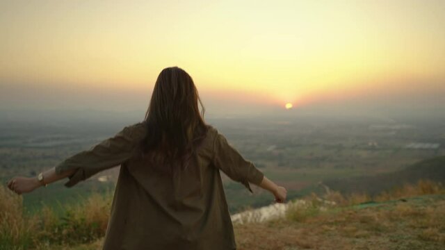 Asians woman caper and watching the beauty of nature in the evening sunset during camping leisure trip,freedom concept , travel
