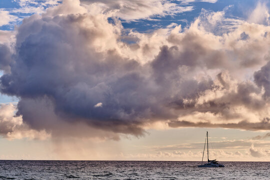 A catamaran is anchored off of Kamaole Beach during sunset in Kihea.