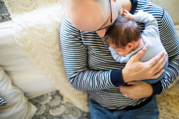 high angle view of father holding, loving his newborn son.
