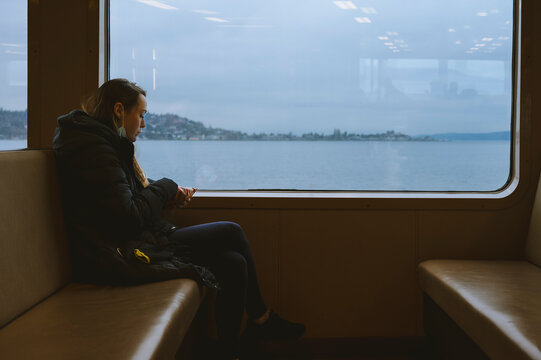 Female sitting on ferry eating a snack with a window view