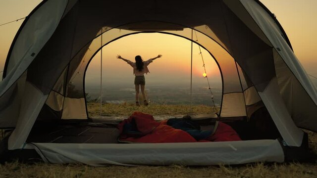Asians woman caper and watching the beauty of nature in the evening sunset during camping leisure trip,freedom concept , travel
