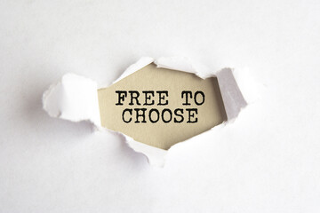 the words free to choose appearing behind torn white paper, gray background