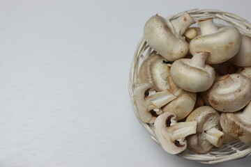 Fototapeta na wymiar Mushrooms in a white basket. Top view on white background. Space for copying.