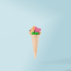 Colorful hearts with ice cream cone on light blue pastel background. Creative love idea. Contemporary style.