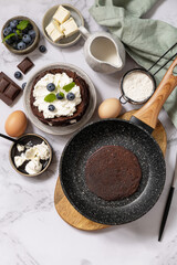 Healthy breakfast. Ingredients for cooking and delicious crepes with blueberries and ricotta on a marble tabletop. Top view flat lay. Copy space.