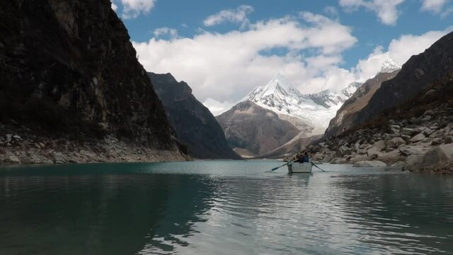 Boat paddles in the mountain lake Paron with its turquoise waters in the high Andes of Peru