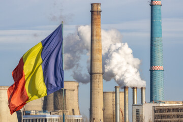 Romanian flag waving with CET Sud Bucharest Thermal Power Plant in the background. Cold winter day....