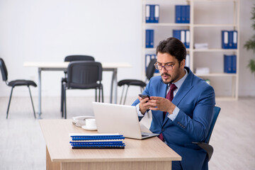Young male employee sitting at workplace