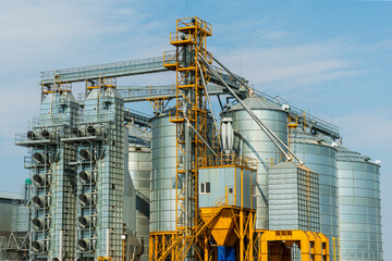 Fototapeta na wymiar A large modern plant for the storage and processing of grain crops. view of the granary on a sunny day against the blue sky. End of harvest season.