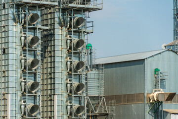 Obraz premium A large modern plant for the storage and processing of grain crops. view of the granary on a sunny day against the blue sky. End of harvest season.