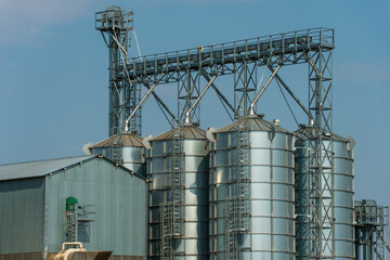A large modern plant for the storage and processing of grain crops. view of the granary on a sunny day against the blue sky. End of harvest season.
