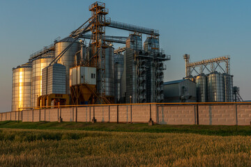 A large modern plant for the storage and processing of grain crops. view of the granary on a sunny day against the blue sky. End of harvest season.