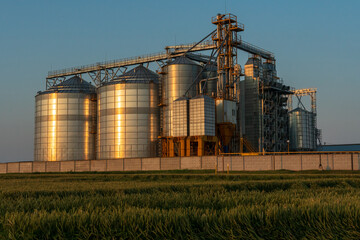 A large modern plant for the storage and processing of grain crops. view of the granary on a sunny day against the blue sky. End of harvest season.