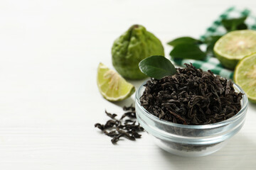 Dry bergamot tea leaves and fresh fruits on white wooden table, space for text
