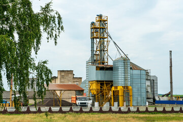 silver silos on agro manufacturing plant for processing drying cleaning and storage of agricultural products, flour, cereals and grain. Large iron barrels of grain. Granary elevator