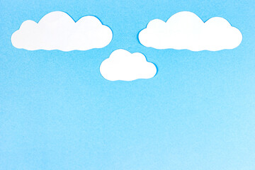 Bright blue sky with white paper clouds as a craft textured heaven template or cloudscape background with copy space.