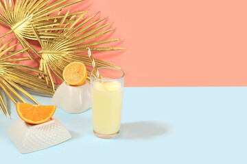 Modern still life with citrus, orange smoothie and ingredients on stand and podiums on pink background with golden palm leaves, minimal detox diet concept, summer vitamin drinks, selective focus,