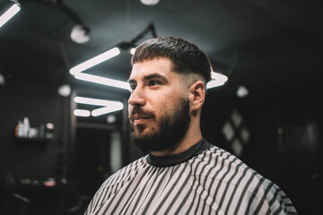 Young man client at barbershop getting haircut hipster portrait