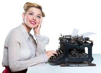 Retro woman working in office with vintage typewriter and phone, dressed in pin-up style