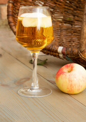 A glass of apple wine,cider, juice . Ripe summer apples are lying nearby