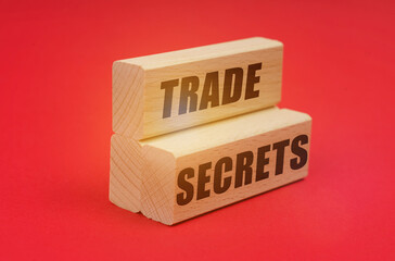 On a red background, wooden blocks with the inscription - TRADE SECRETS