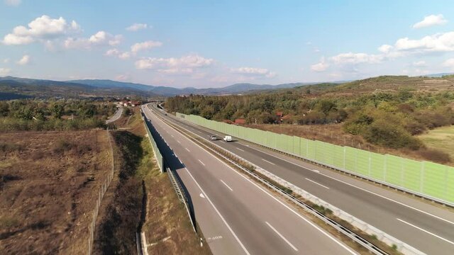 Straight motorway highway. Cars passing. Sound barriers. Straight motorway highway. Cars passing. Sound barriers. Aerial drone shot, flying low.