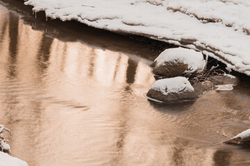 Stones in the stream. a small river in a snowy forest.close-up.. Winter nature.